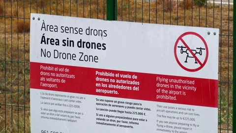 No drone zone warning sign on fence near Valencia airport runway Stock Footage 344971468