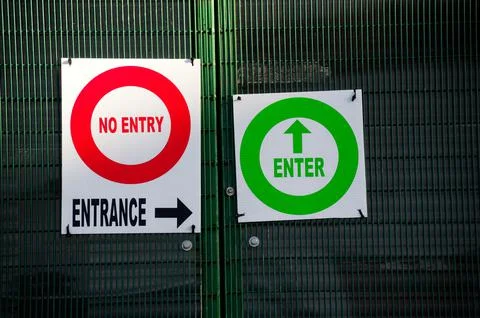 No entry and enter direction arrow sign at construction site entrance gate Stock Photos