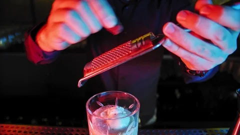 No face bartender is pouring coctail into the glass at the bar stand. 4K Stock Footage 99249498