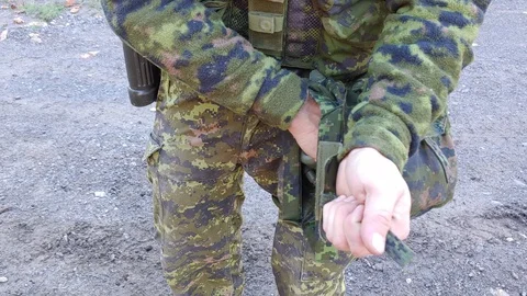 No face visible when soldier takes out gas mask from uniform belt pocket 스톡 동영상 126937835