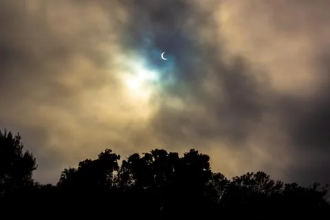 No filter Solar Eclipse with cloudy glow through marine layer clouds Stock Photos