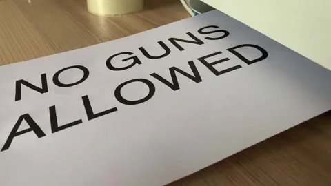 “No guns allowed” black text word on paper sheet A4 out of printer scanner Stock Footage 249576482