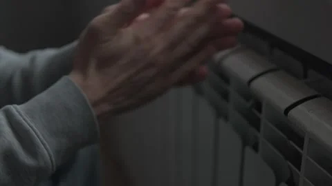 No heating at home, warming hands near radiator in cold apartment, close up Stock Footage 327804424
