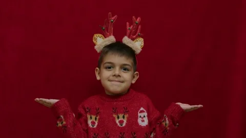 No idea. Helpless hand gesture of cute child in christmas ugly sweater and with Stock Footage 257830582