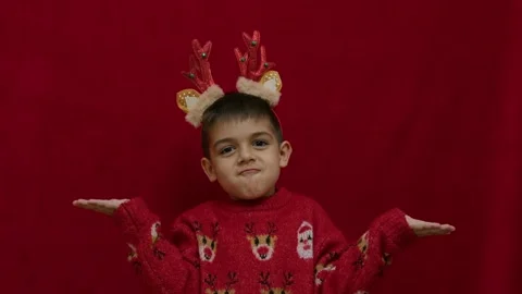 No idea. Helpless hand gesture of cute child in christmas ugly sweater and with Stock Footage 257830652