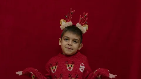 No idea. Helpless hand gesture of cute child in christmas ugly sweater and with Stock Footage 257830677