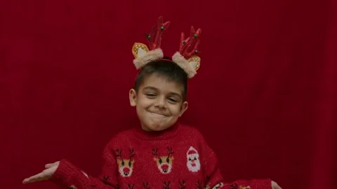 No idea. Helpless hand gesture of cute child in christmas ugly sweater and with Stock Footage 257830707
