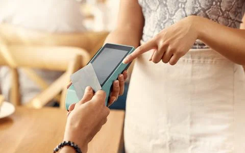 No need for long queues. a customer using a nfc machine to make a card payment Stock Photos