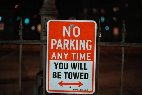 No Parking Any Time You Will Be Towed Sign In A Dark Parking Lot At Night Stock Photos