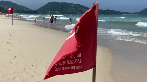 No swimming here red flag flapping caution for tourists safety on beachfront Stock Footage 280846902