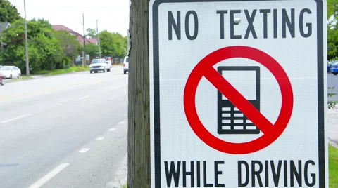 NO TEXTING WHILE DRIVING sign dangerous practice Stock-Footage 56658211