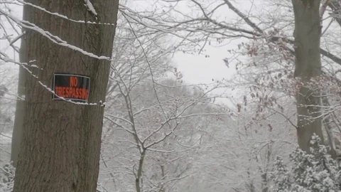 No trespassing sign tilt down during snow storm Stock Footage