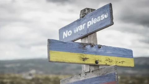 No war please text quote on wooden signpost outdoors on nato colored flag, uk Stock Footage 171028424