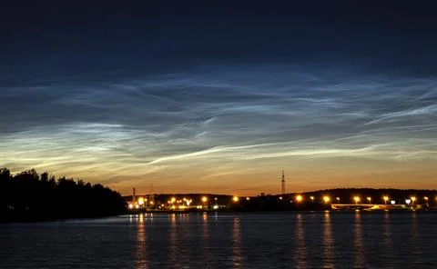 Noctilucent clouds glowing over a river Stock Photos