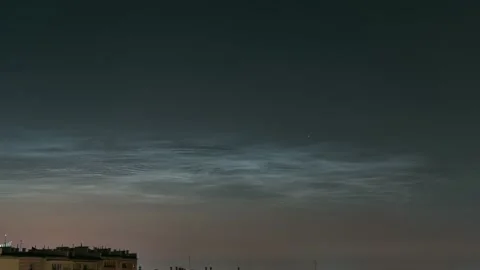 Noctilucent clouds shining in the summer night sky timelapse with some buildings Stock Footage 157228246