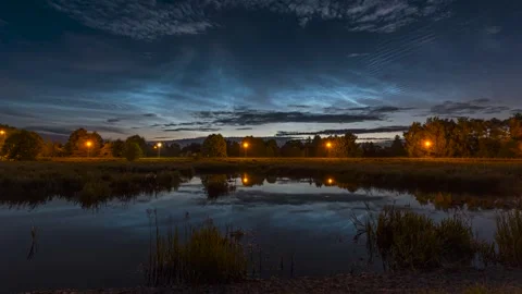 Noctilucent clouds in a time-lapse technique seen over the riverbank Stock Footage 301406405