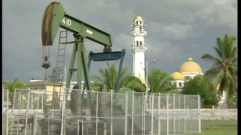 Nodding donkey (pumpjack) and mosque in background, Brunei Darussalam (1995) Stock Footage 134348241