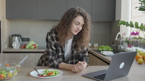 Nodding While Listening On Video Call In Cozy Kitchen With Fresh Salad Nearby Stock Footage 311270067