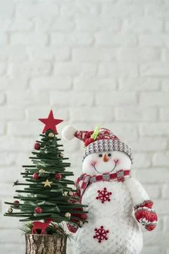 Noel background with pine tree and snowman over brick wall Stock Photos