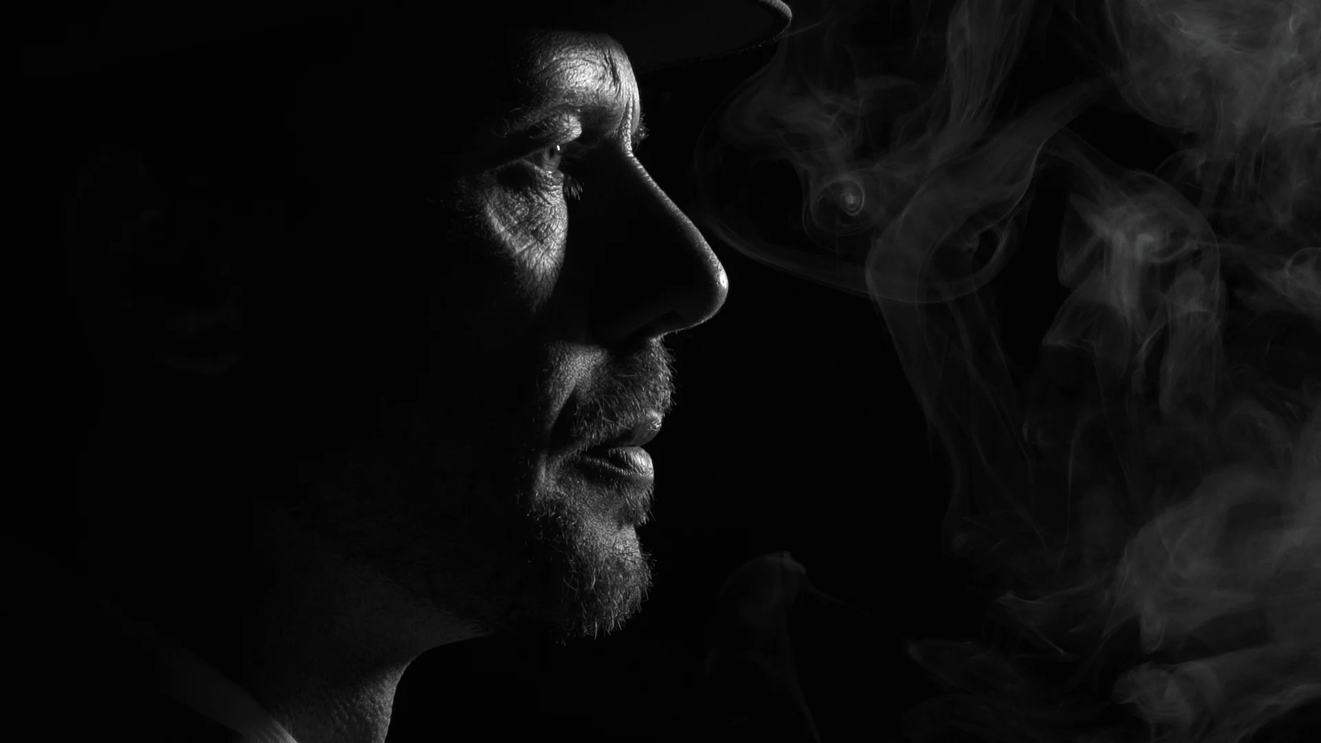 Noir detective smoking a cigarette in the dark