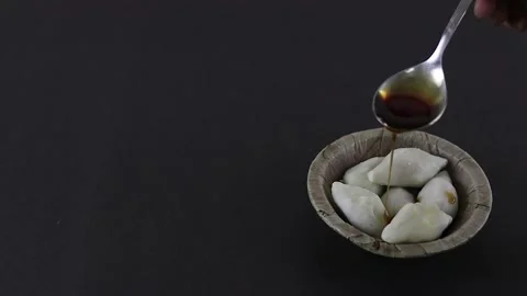 Nolen gur or date palm jaggery poured over puli pithe or bengali rice flour.. Stock-Footage 229478919