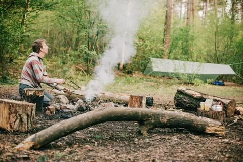 Nomad creating a campfire in spring forest. Stock Photos