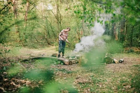 Nomad creating a campfire in spring forest. Stock Photos