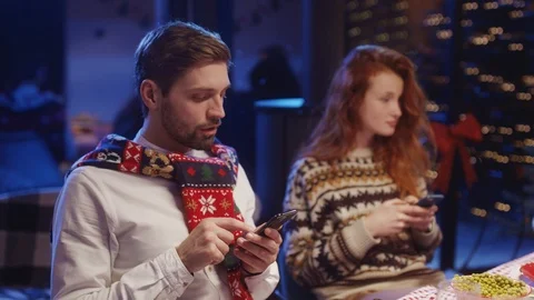 Nomophobia. On Christmas night, young multi-race friends using mobile phones for Stock Footage 121593036