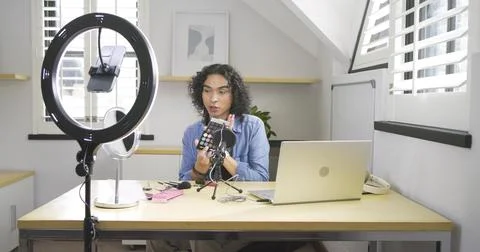 Non-binary creator picking up palette, rotating shades, opening red-lid tube at Stock Photos