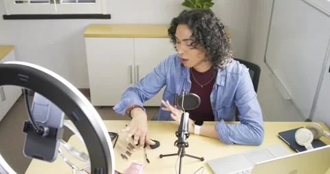 Non-binary creator with ring light picking lipstick, tapping brush brushing Stock Footage 339320497