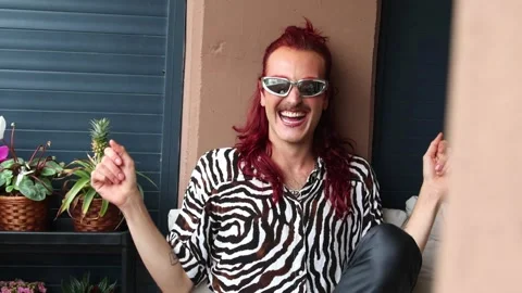 Non-binary influencer laughing and having fun on a balcony Stock Footage 309187489