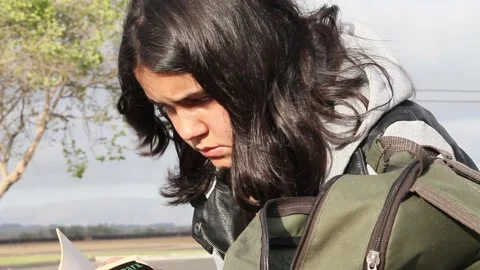 Non binary kid reading book outside Stock Footage 155388115