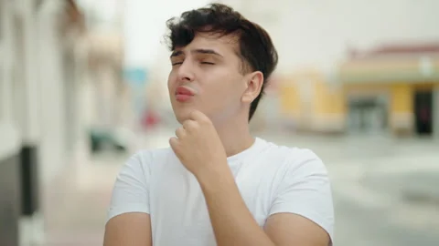 Non binary man standing with doubt expression at street Video stock 231510029