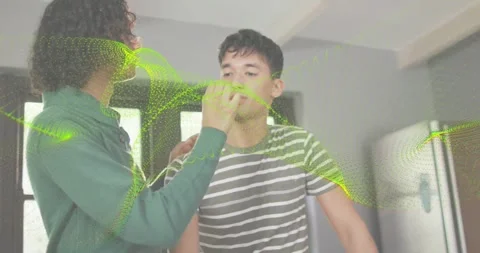 Non-binary offering red sample for taste test, feeding him by counter, green Stock Footage 328246488