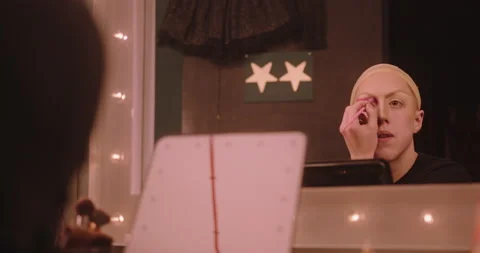 Non-Binary Person Applying Drag Queen Make-up Backstage, looking in Mirror Stock Footage 194249254