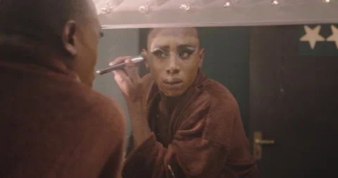 Non-Binary Person Applying Drag Queen Make-up Backstage, looking in Mirror Stock Footage 194254319