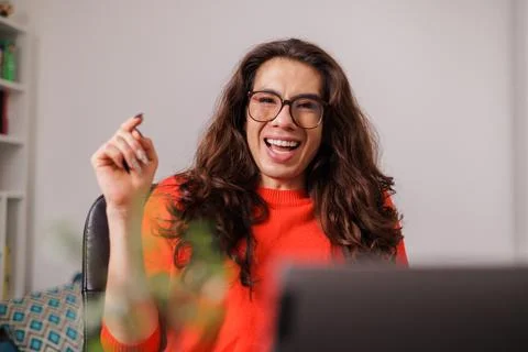 Non-binary person behind desk with big smile Stock Photos