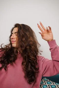 Non-binary person dancing on the couch at home Stock Photos