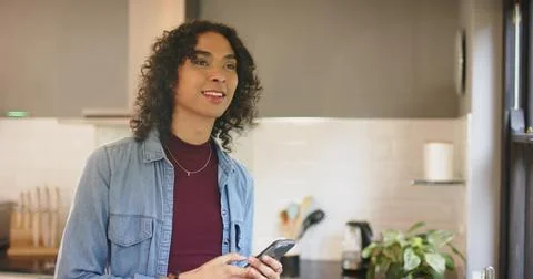 Non-binary person glancing at smartphone while waiting then sipping from ceramic Stock Photos