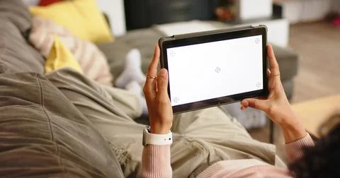 Non-binary person lifting tablet to calibrate screen and adjusting angle on Stock Photos