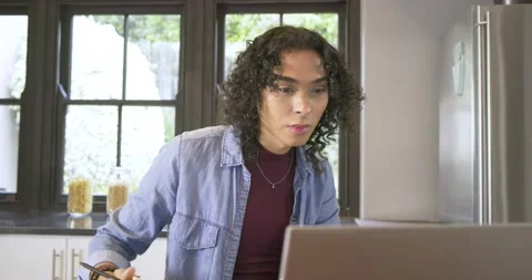 Non-binary person picking tote bag, writing notes, scrolling laptop and packing Stock Footage 341851553