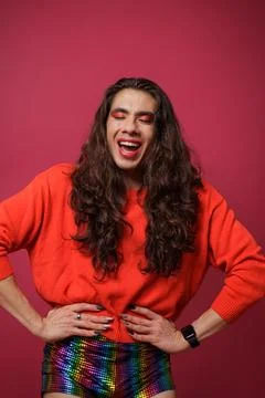 Non-binary person is posing on a red studio background Man has an artistic .. Stock Photos