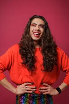 Non-binary person is posing on a red studio background Man has an artistic .. Stock Photos