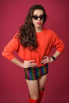 Non-binary person is posing on a red studio background Man has an artistic .. Stock Photos