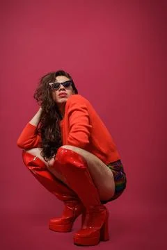 Non-binary person is posing on a red studio background Man has an artistic .. Stock Photos