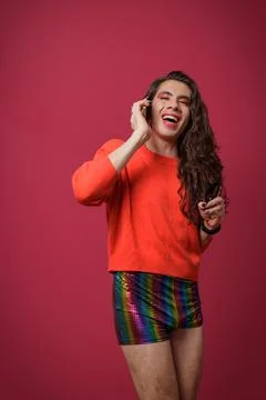 Non-binary person talking on cell phone with a happy expression on their face Stock Photos
