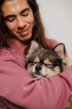 Non-binary person, with their pet on the sofa very happy with lots of love Stock Photos
