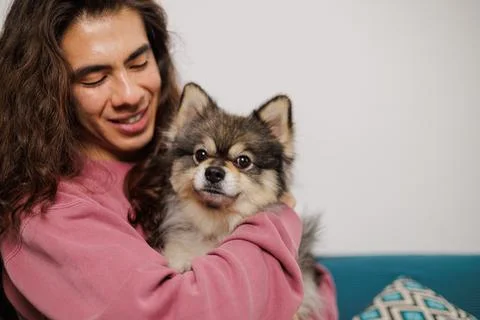 Non-binary person, with their pet on the sofa very happy with lots of love Stock Photos