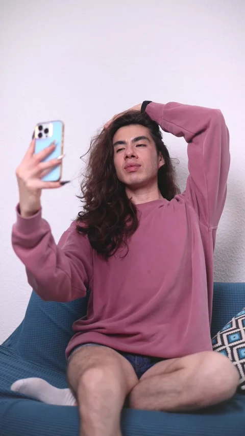 Non-binary person using their cell phone at home with blurred background. Long Stock Footage 309137704