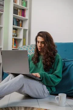 Non-binary person, working from home with their laptop with a happy face Stock Photos